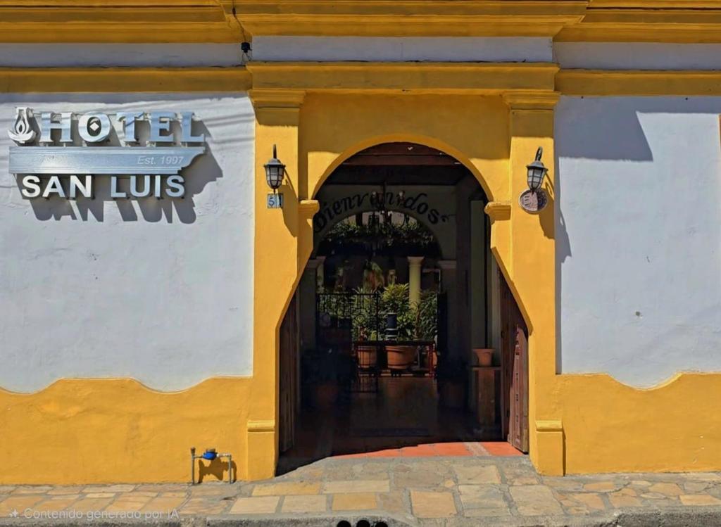 un bâtiment jaune avec une entrée vers un restaurant dans l'établissement Hotel San Luis, à San Cristóbal de Las Casas