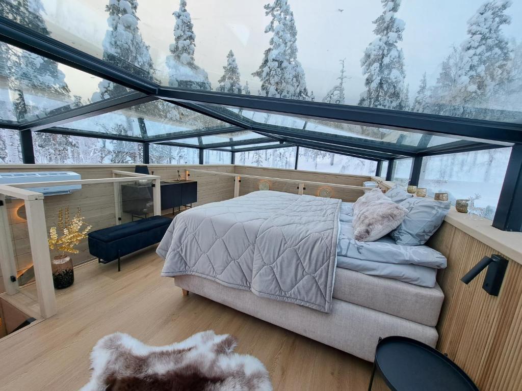 a bedroom with a bed in a glass house at Levi Lapland Luxury Igloos C in Levi