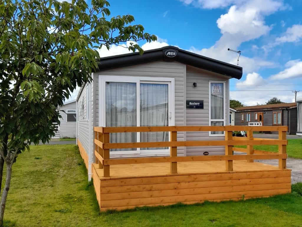 a tiny house with a porch and a fence at Yew in Denny