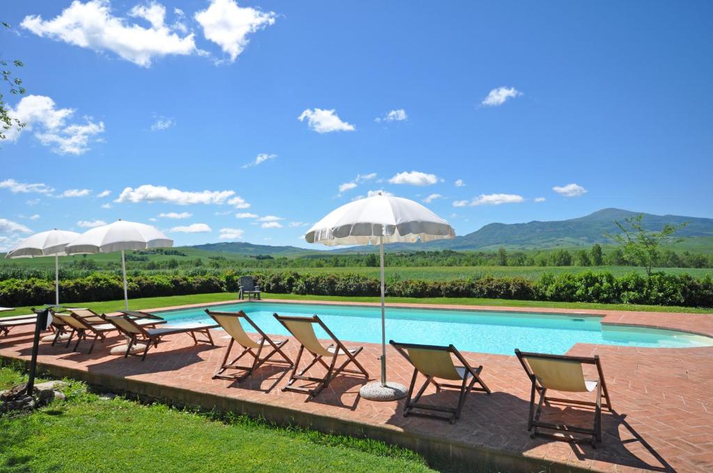 a group of chairs and umbrellas next to a pool at Pienza by PosarelliVillas in Pienza