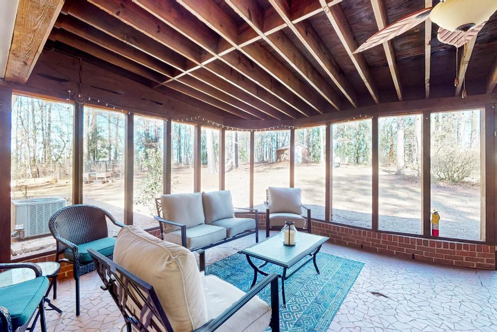 a living room with chairs and tables and windows at 6 Mi to Dtwn: 'Macon Memories' Dog-Friendly Haven in Riverside Park