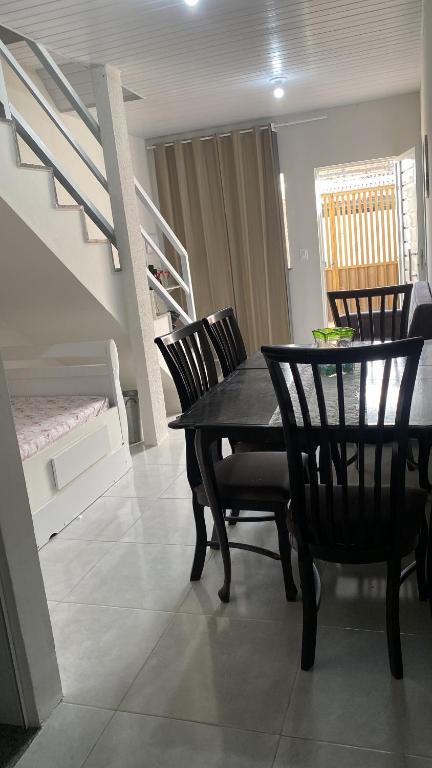 a dining room with a table and chairs and a staircase at Lar Aconchego climatizado e compartilhado in Aracaju