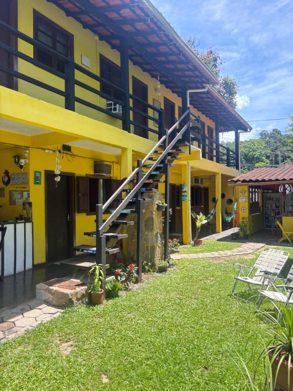 a yellow building with a staircase in front of it at Pousada Lua Nova in Paraty