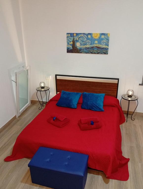 a bedroom with a large red bed with blue pillows at Appartamento rosso blu in Vernazza