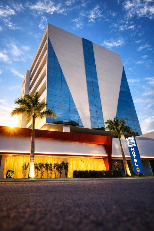 a building with a palm tree in front of it at Samba Rio Bonito in Rio Bonito