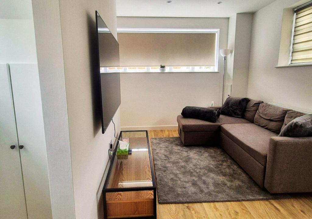a living room with a couch and a mirror at Cosy & Luxury 2BR Flat in Calverton in Calverton