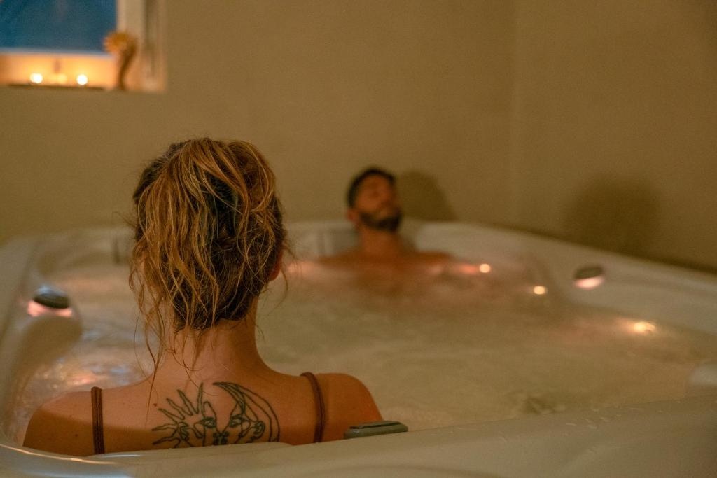 a woman sitting in a bath tub with a man at New Wellness & Spa Boutique Residence Rovinj in Rovinj