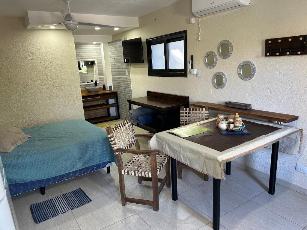 a living room with a table and a bed at Departamento para 2 pers con vista a las sierras OC in Villa Giardino