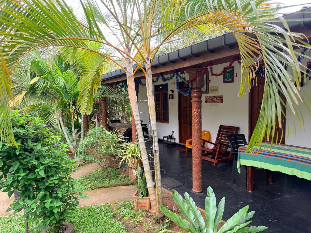 a house with a palm tree in front of it at Green Lake Sigiriya in Sigiriya