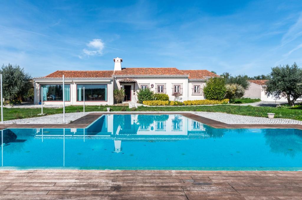 a swimming pool in front of a house at Casal do Aviador in São Vicente do Paul