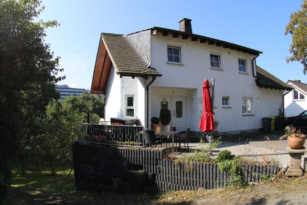 una casa blanca con un paraguas rojo delante de ella en Pension Garni Haus Bismarckhöhe en Bad Ems