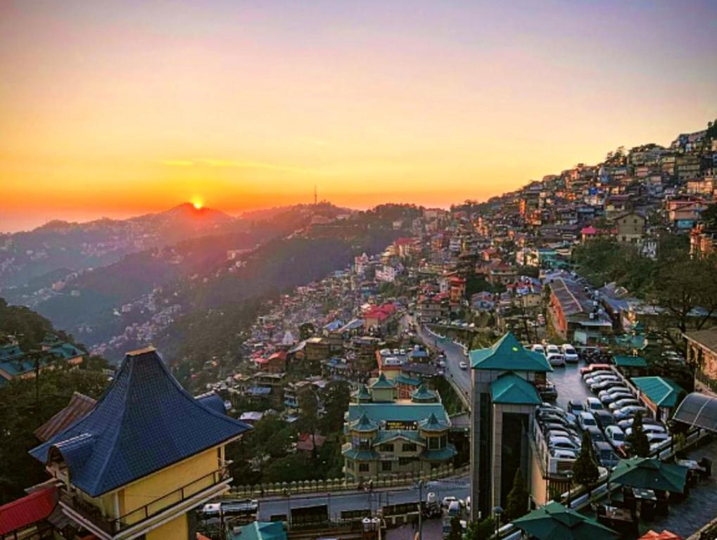 a view of a city with the sunset in the background at The Boho BNB in Shimla