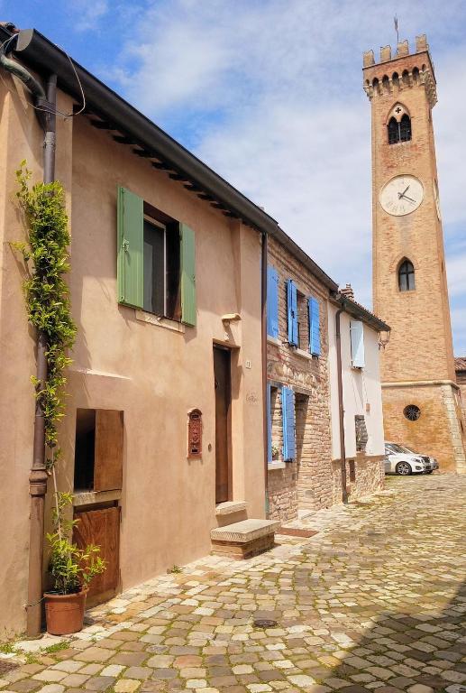 a building with a tower with a clock on it at CasAlice Room & Breakfast in Santarcangelo di Romagna
