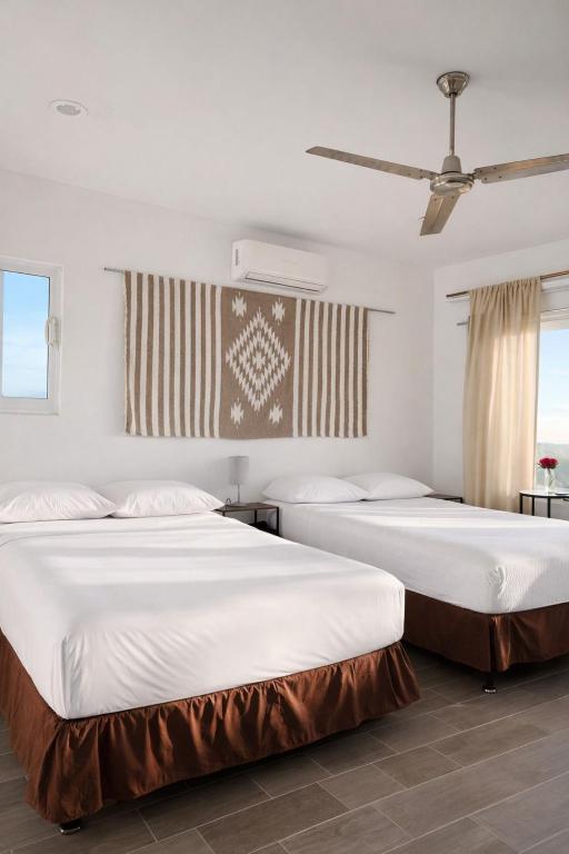 two beds in a room with american flags on the wall at The Colony La Ventana in La Ventana