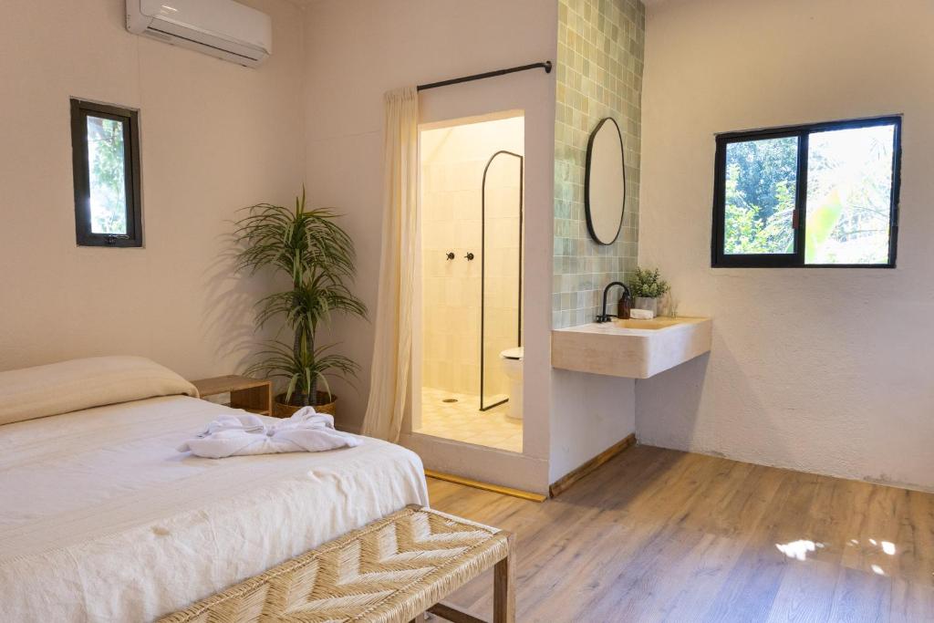 a bedroom with a bed and a bathroom with a sink at La Punta SurfHouse in Brisas de Zicatela