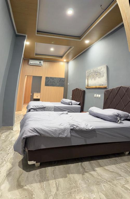 two beds in a room with a ceiling at MH Villa Deluxe Twin in Pancor