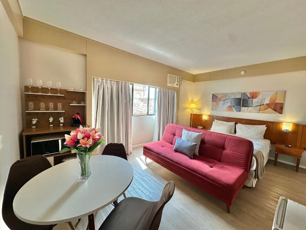 a living room with a red couch and a table at Flat Borges Lagoa com vaga de garagem, UH412 in São Paulo
