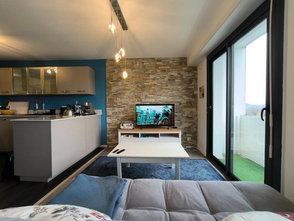 a living room with a couch and a kitchen at Spacious Quiet Pyrenees View Garage in Pau