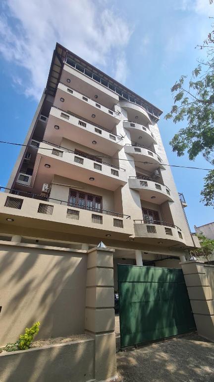 a tall building with a garage in front of it at Oceanway Residences in Wattala