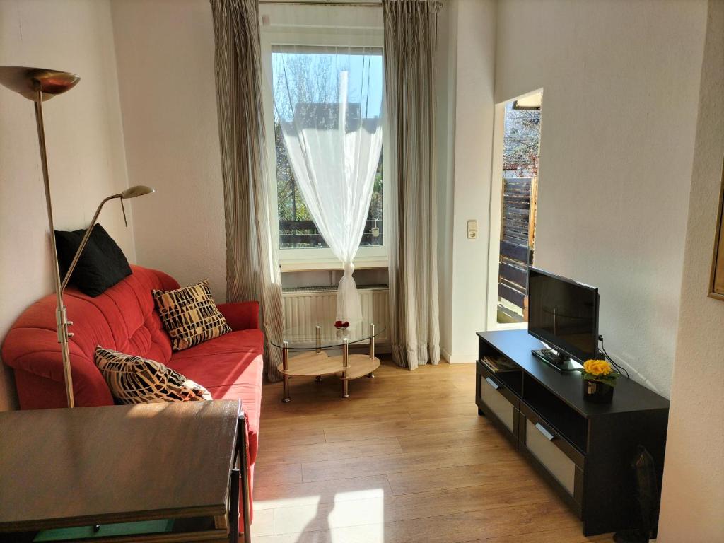 a living room with a red couch and a television at Eulennest-lu in Ludwigshafen am Rhein