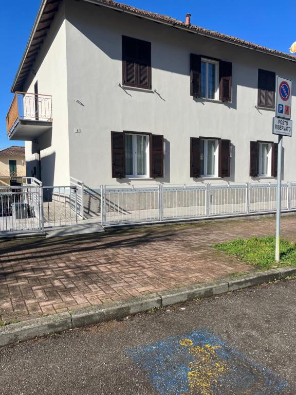 a white building with a fence in front of it at Casa RAFAEL & GINEVRA in Stazzano