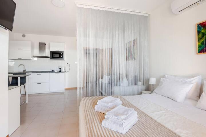 a white room with a bed and a kitchen at Casa Valentina 2 in Perugia