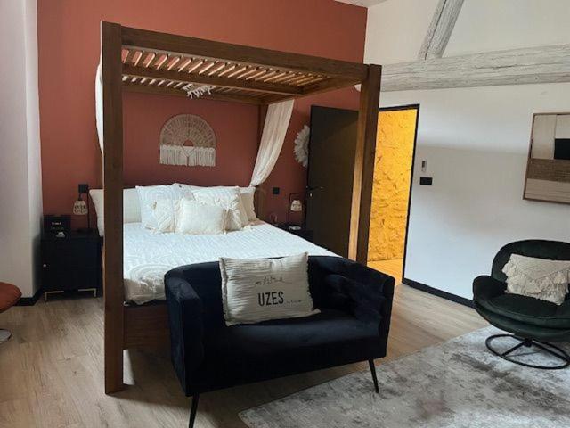a bedroom with a canopy bed and a chair at chez Jess chambre d'hôte a UZES in Uzès