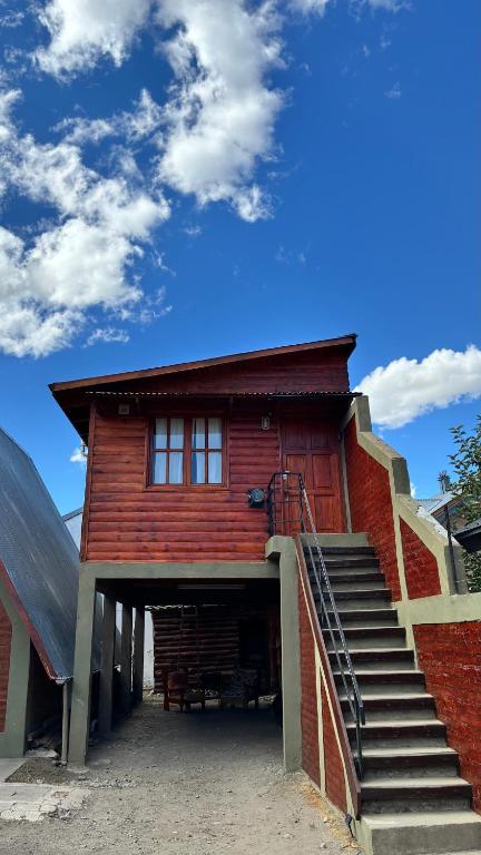 a red building with stairs leading up to it at La martina in Junín de los Andes