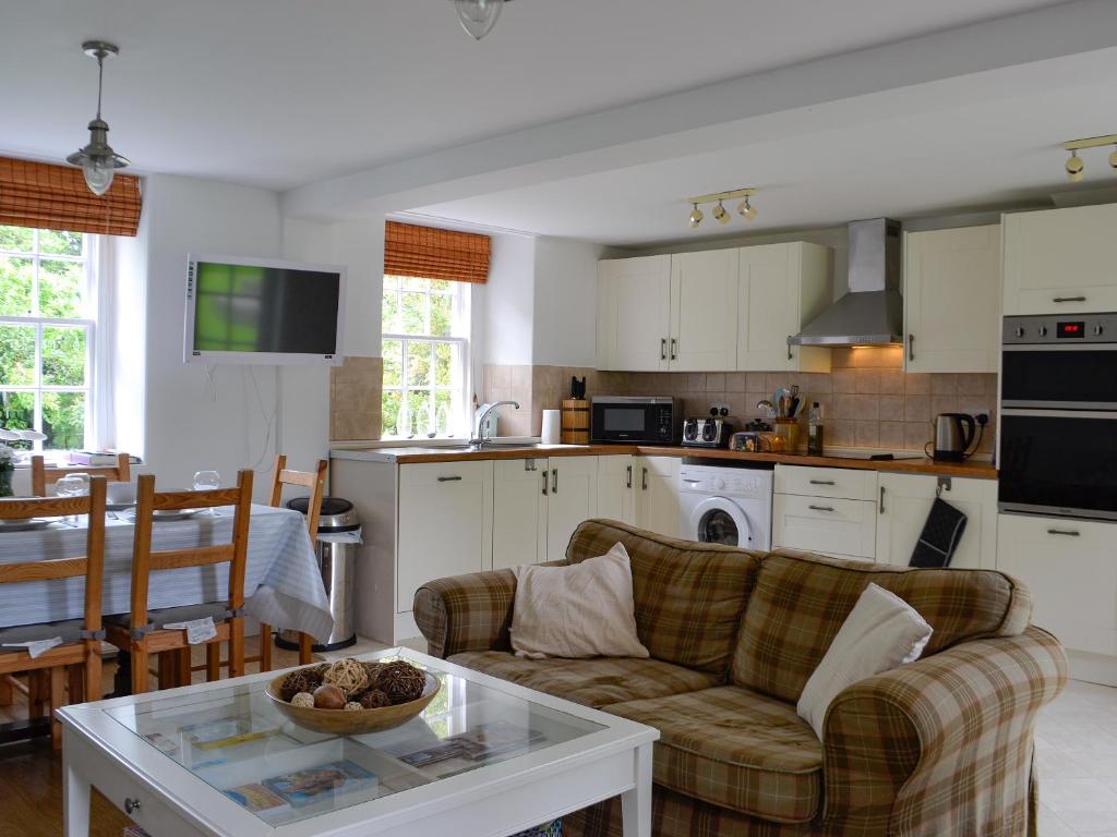 a living room with a couch and a table at Orchard Cottage - Uk12525 in Garlieston