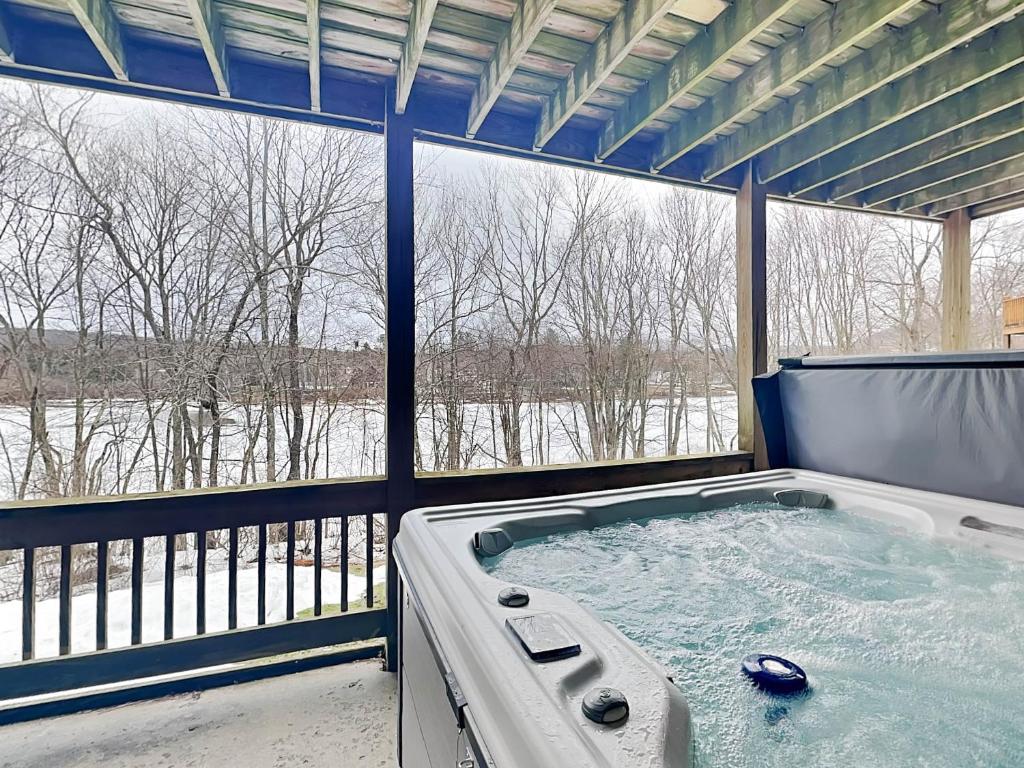 a jacuzzi tub in a room with a large window at Duck Cove at Wisp in McHenry