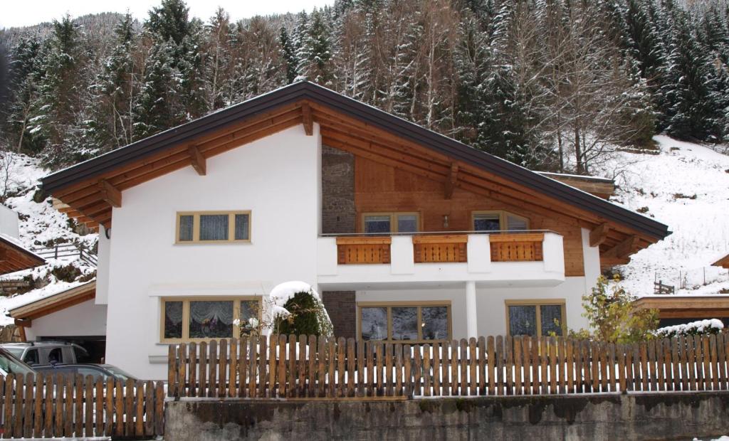ein Haus mit einem Holzzaun davor in der Unterkunft Ferienwohnungen Eiter Fridolin in Zaunhof