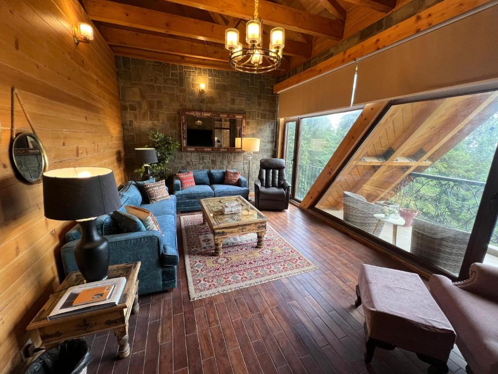a living room with a couch and a table at Alpine Home By HespakBNB in Dunga Gali