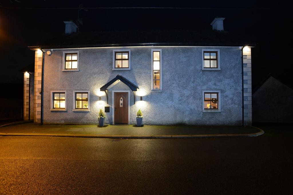 a blue house with lights on the front at night at Beech House in Antrim
