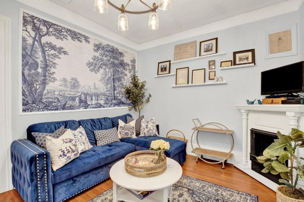 a living room with a blue couch and a fireplace at Haint & Porcelain in Savannah