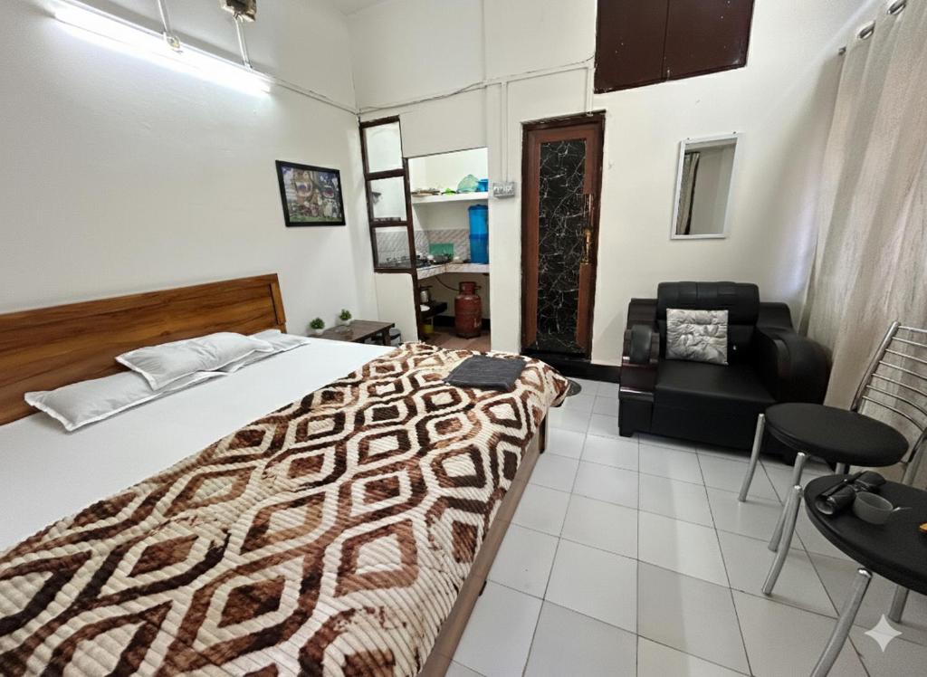 a bedroom with a bed and a couch and a chair at The Quiet corner 1RK Downtown in Guwahati