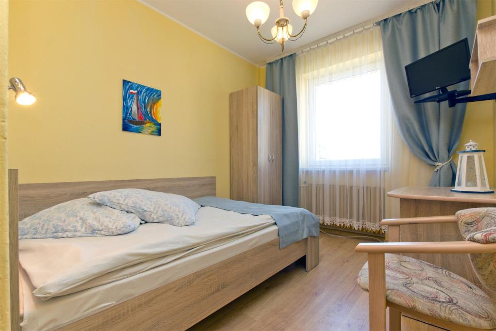 a small bedroom with a bed and a window at Willa Irena in Karwia