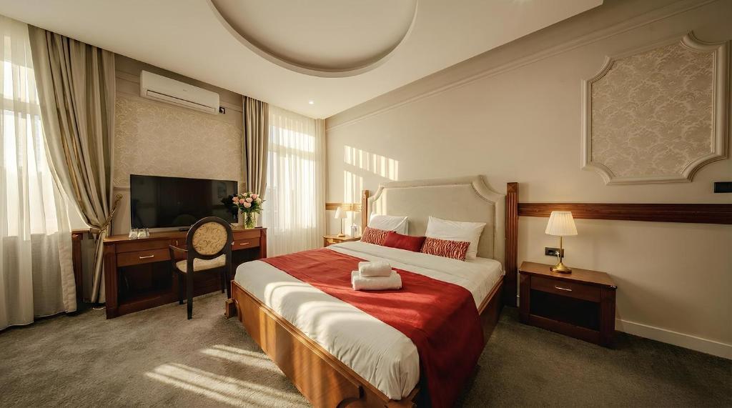 a hotel room with a bed and a desk and a television at 49 Park Villa in Belgrade