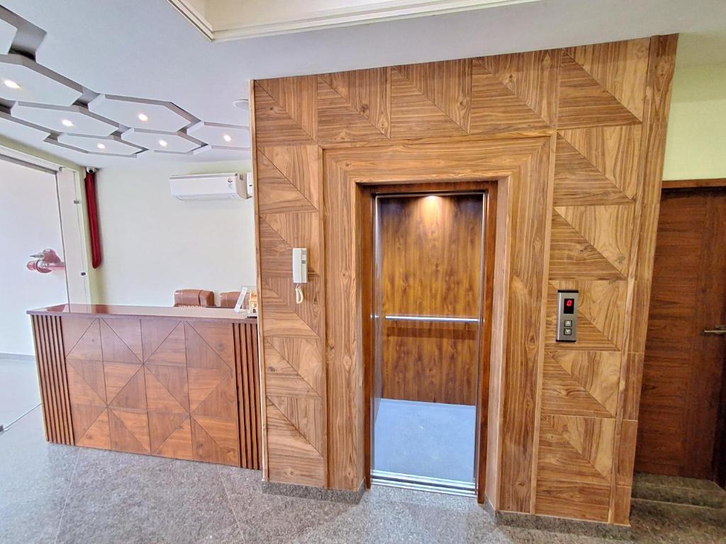 a wooden door in a room with a counter at HOTEL AROMA CROWN in Zirakpur