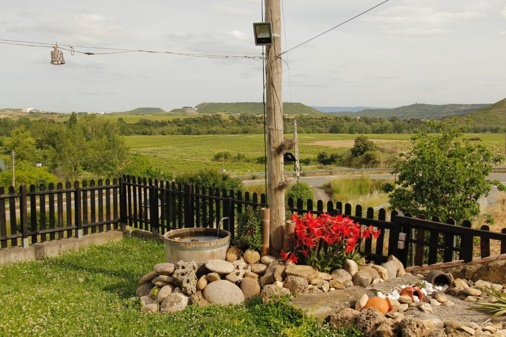 a garden with a fence and flowers and a pole at "Dobela Enea" Cueva alojamiento privado in Laguardia