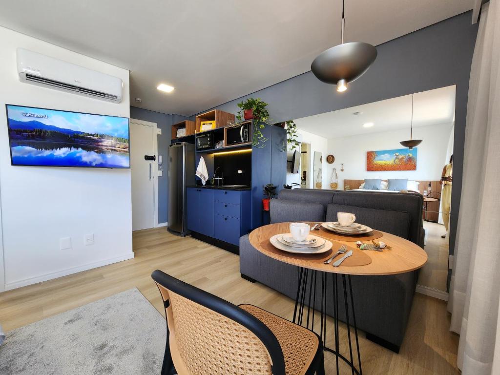 a living room with a table and a couch at Loft próximo à Oktoberfest Blumenau in Blumenau