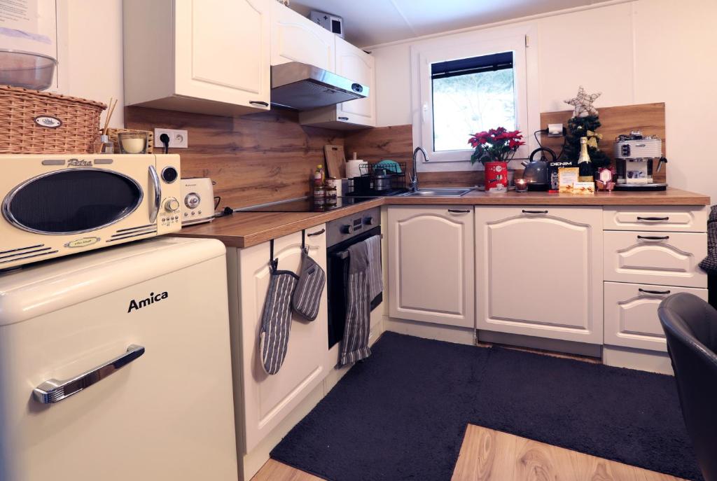 a small kitchen with white cabinets and a microwave at Chata Bella Donovaly in Donovaly