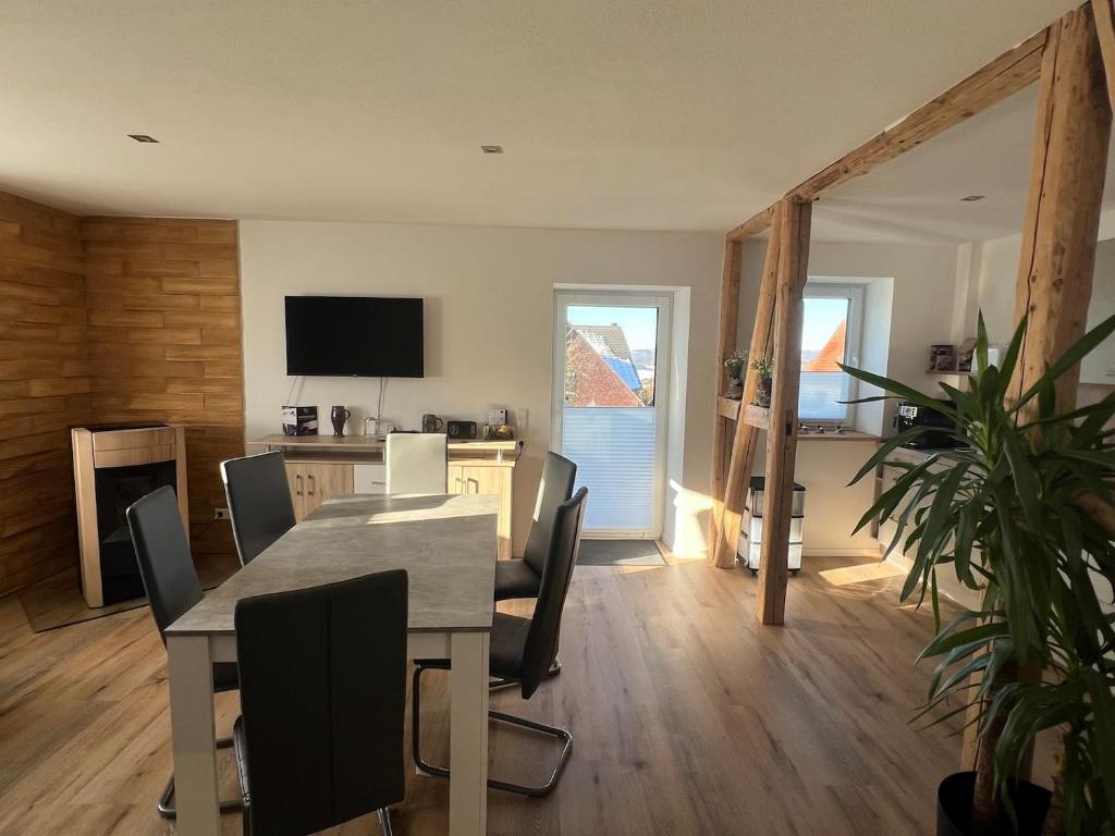 a dining room with a table and chairs and a television at Ferienwohnung Wanderlust in Marsberg