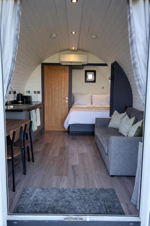 a room with a bed and a couch and a table at Millfield Glamping Pods - Heatherhouse in Orkney