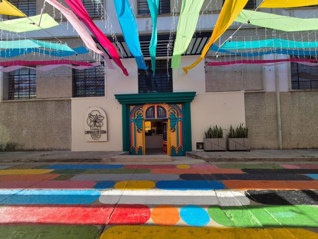 Ein Gebäude mit einem regenbogenfarbenen Boden vor einer Tür in der Unterkunft Hostal Capullode Seda in Zapatoca