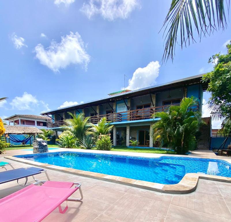 a swimming pool in front of a building at Pousada Manga Azul in Barra de Camaratuba