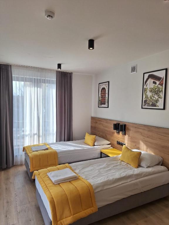 a hotel room with three beds and a window at VILLA 17 Noclegi in Płock