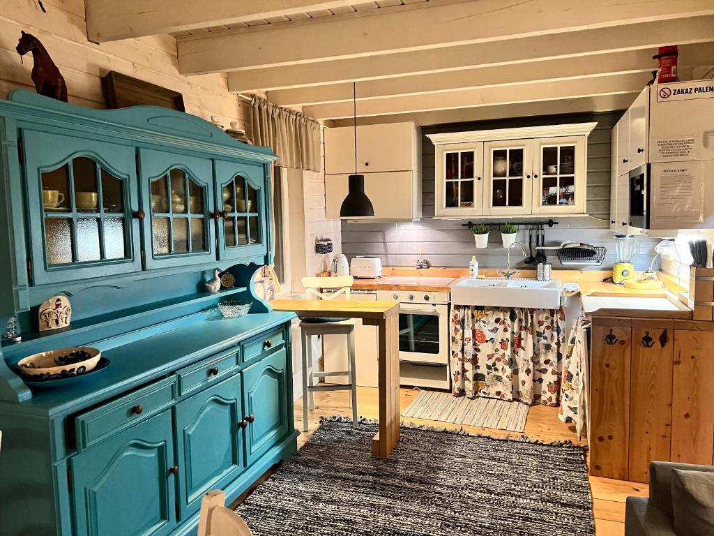 a kitchen with blue cabinets and a table at Domki nad morzem Sasino Mojo Miodno Checz in Sasino