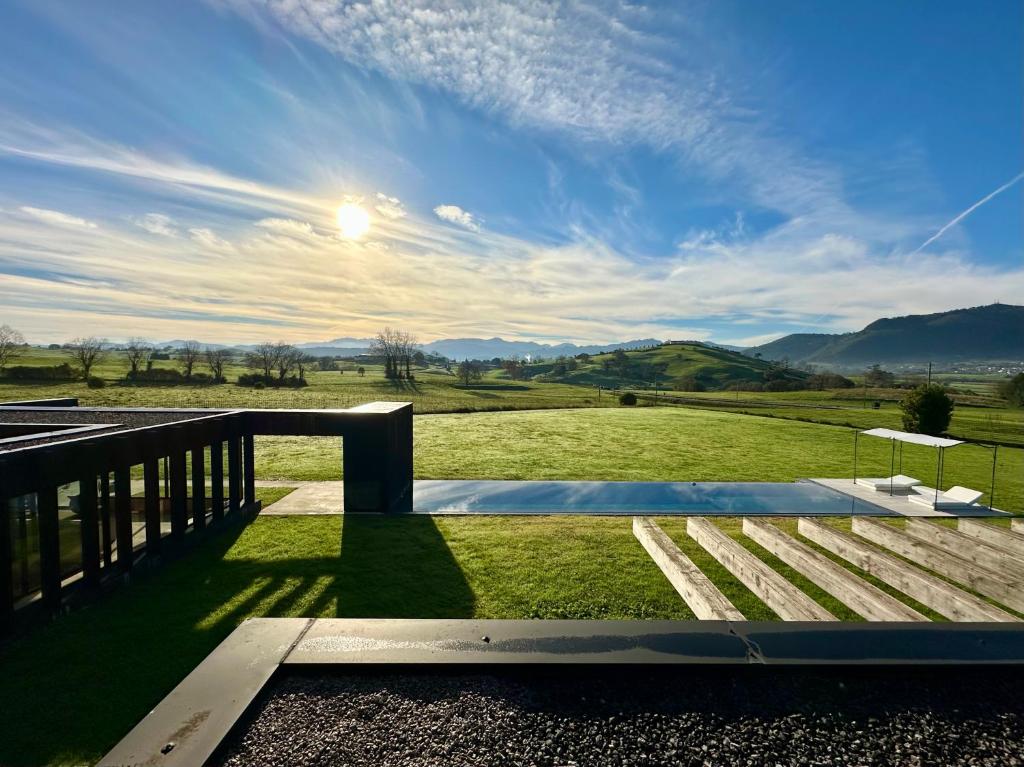 a deck with a view of a grassy field at Casa Anjana in Rubayo