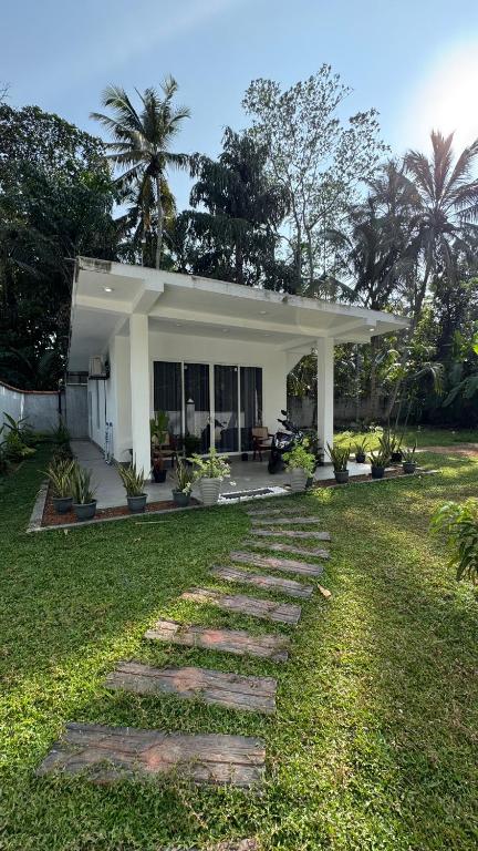 a house with a walkway in front of a yard at Hideaway in Bentota