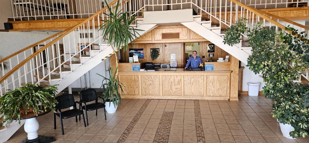 a woman standing at a counter in a building at Rodeway Inn Roswell in Roswell
